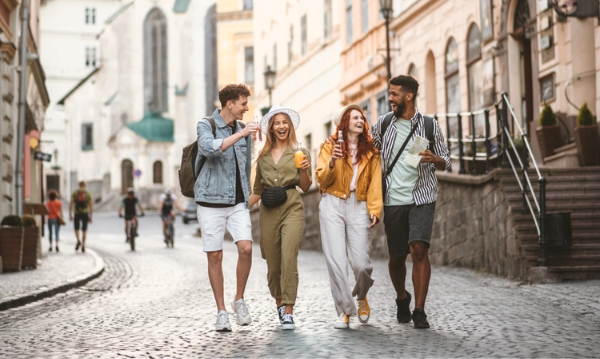 Cuatro amigos caminando en la ciudad y sonriendo