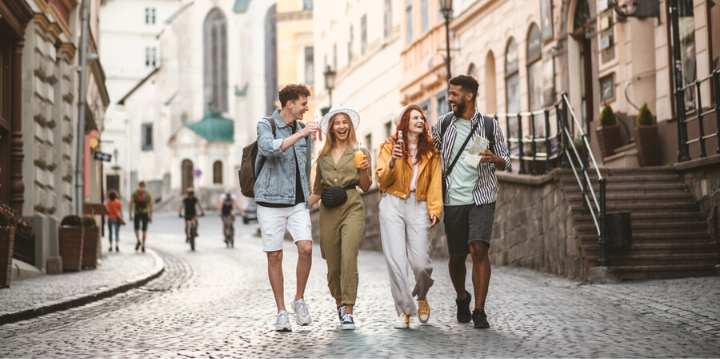 Cuatro amigos caminando en la ciudad y sonriendo